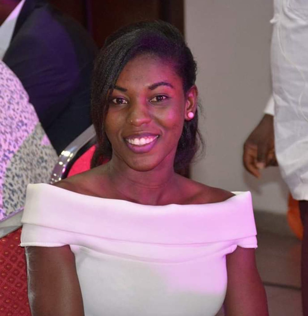 A woman in white dress smiling for the camera.