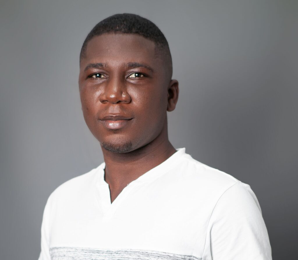 A man in white shirt standing next to wall.