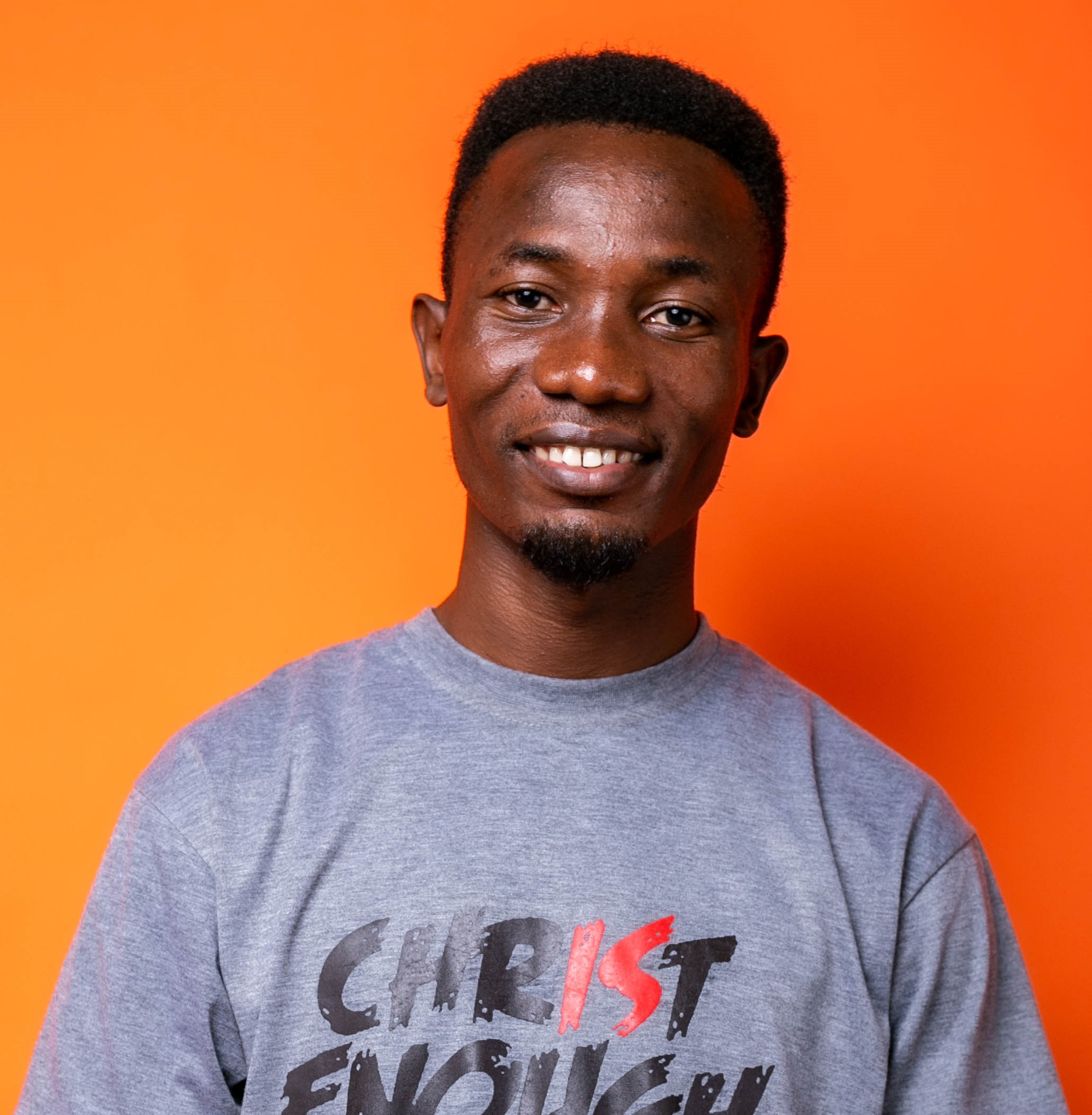 A man standing in front of an orange wall.